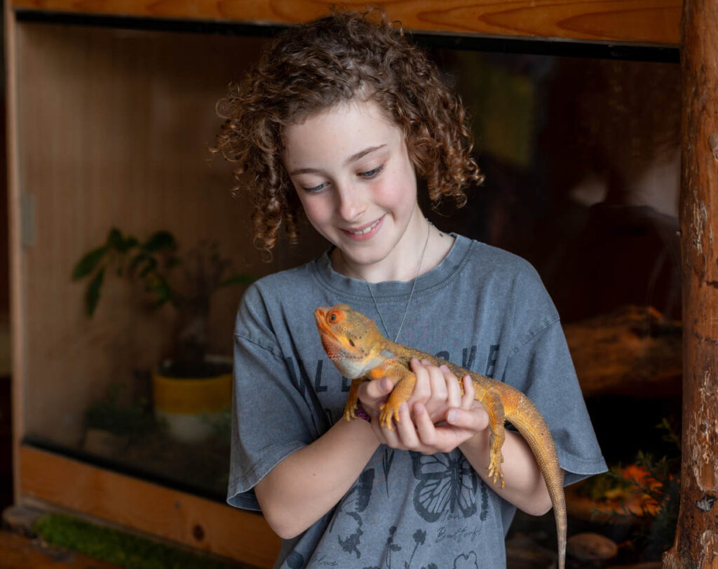 Child holding lizard